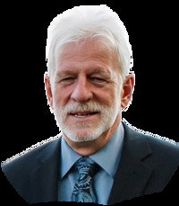 Portrait of a smiling, bearded man in a suit.