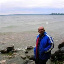 Person standing by a rocky lakeshore.