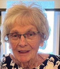 Elderly woman smiling indoors with glasses