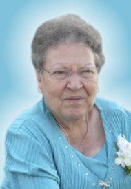 Elderly woman in blue dress smiling gently