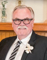Smiling person in glasses and suit at event