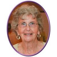 Smiling elderly woman with glasses and earrings.