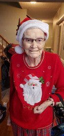 Elderly woman in festive Christmas sweater and hat