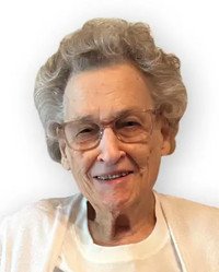 Elderly person smiling warmly with glasses.