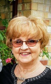 Smiling woman with sunglasses near brick wall