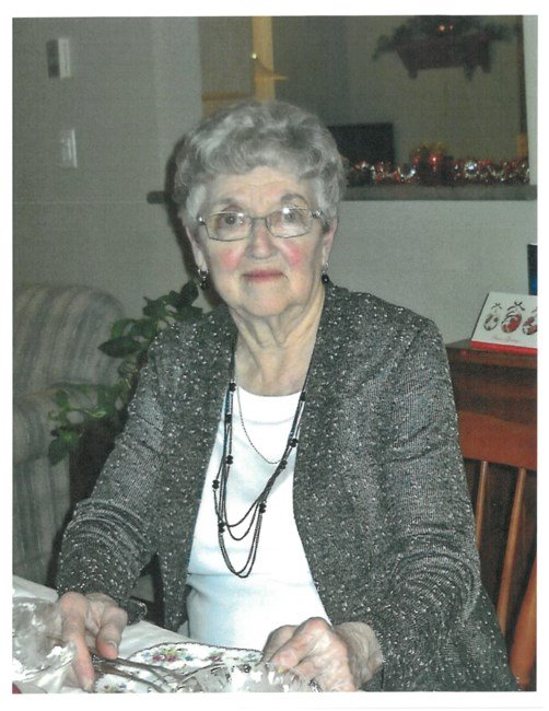 THOMPSON, Mary Eleanor Thompson Elderly woman in glasses sitting inside, smiling.