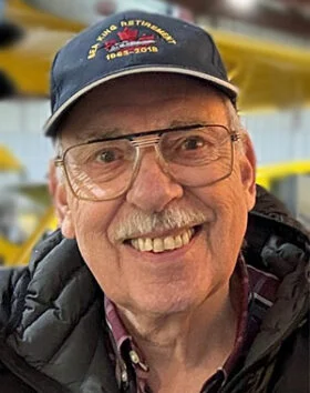 Smiling man wearing a cap indoors.