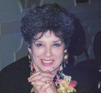 Smiling person at table with floral accessories.