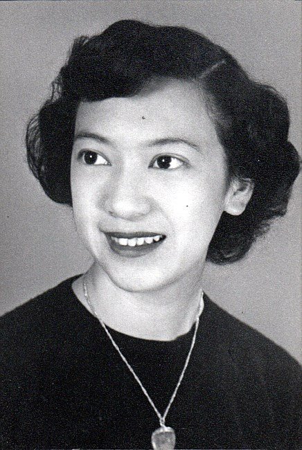 Vintage portrait of a smiling woman with necklace.