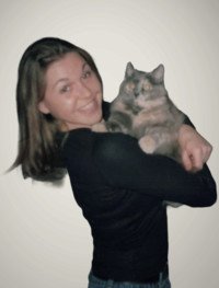 Woman happily holding a fluffy gray cat.