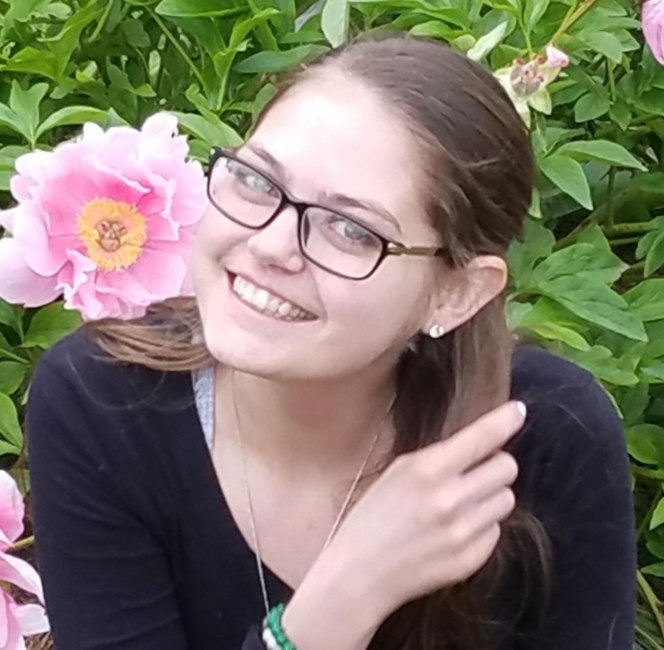 WELDON , Melissa Lauren Weldon Smiling person with glasses near pink flowers