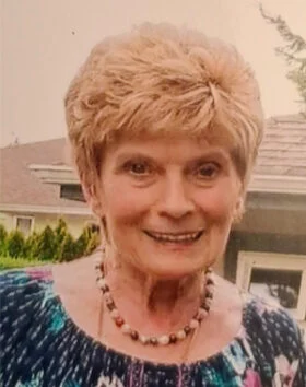 Smiling woman outside in front of house