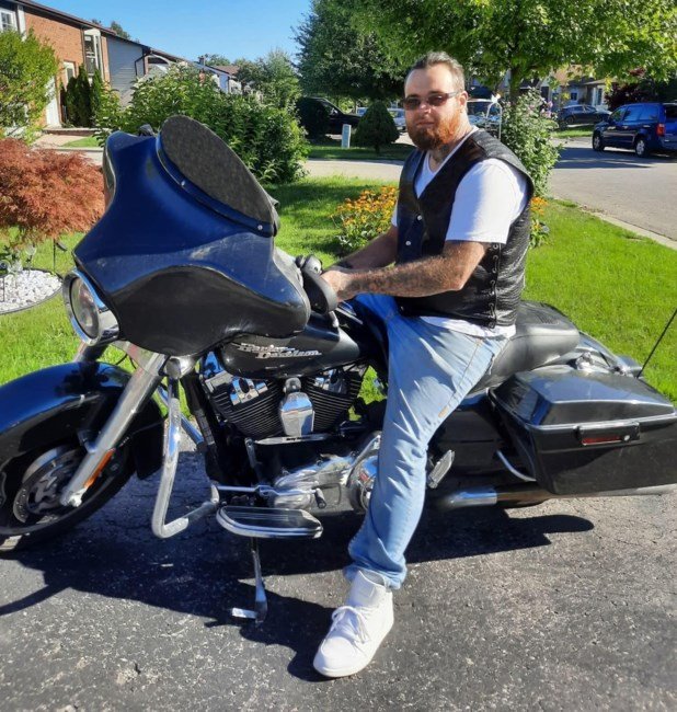 Man sitting on a motorcycle outdoors.