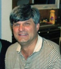 Smiling person wearing striped shirt indoors.