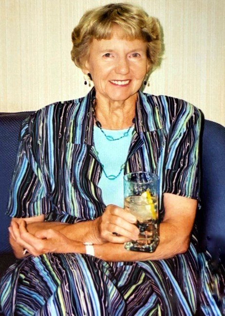Smiling woman holding a glass with lemon.