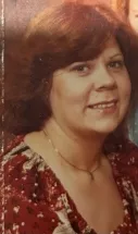 Smiling person in red floral shirt, vintage photo.