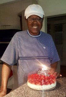 Man smiling with birthday cake and candle