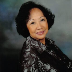 Smiling woman in patterned jacket portrait.