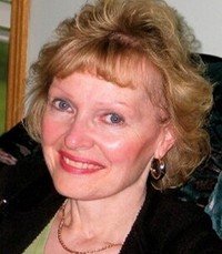 Smiling person with short blonde hair.