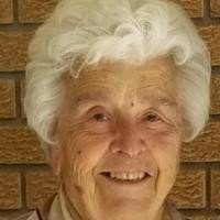 Smiling elderly person in front of brick wall