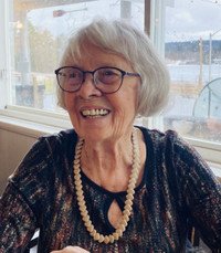 Smiling elderly woman wearing glasses and necklace