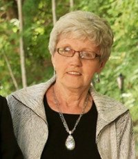 Elderly woman with gray hair and glasses outside.