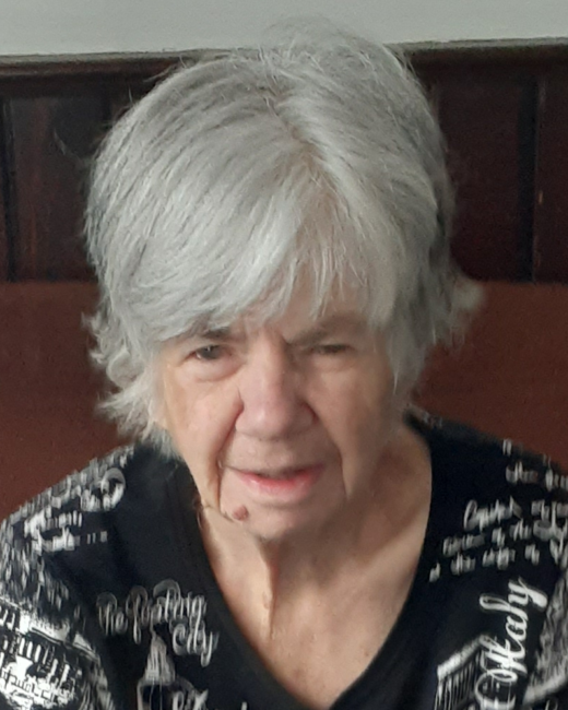Elderly woman with white hair in patterned shirt