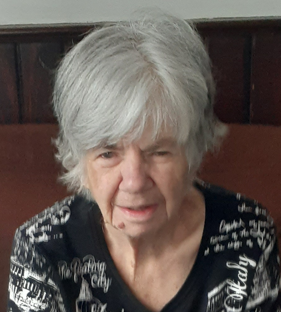 Elderly woman with white hair in patterned shirt