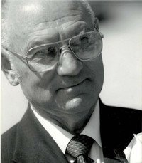 Elderly man in glasses and suit, black and white.