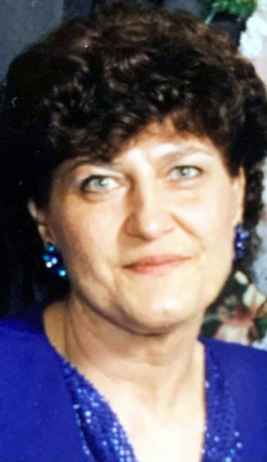 Person with curly hair, wearing blue top.