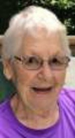Smiling elderly woman wearing glasses and purple shirt