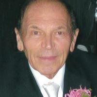 Man in formal attire with a flower corsage.
