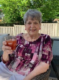 JUUL, Pat Juul Smiling woman holding a drink outdoors.