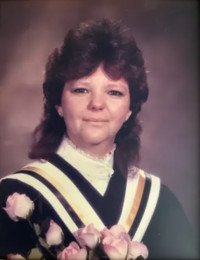 Graduation portrait with roses and academic gown.
