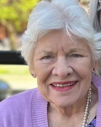 Smiling elderly woman outdoors in sunny weather.