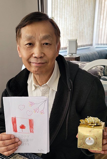 Man with birthday card and gift box smiling.