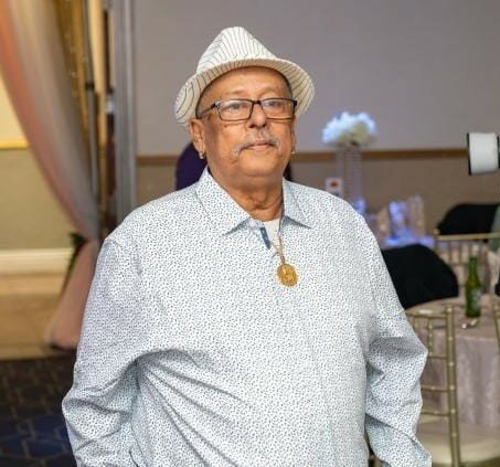 Elderly man wearing hat and stylish shirt indoors