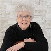 Elderly woman smiling in a black sweater.