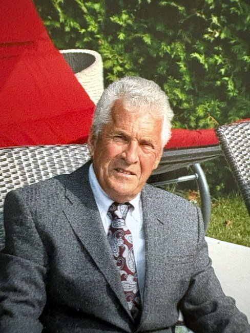 Elderly man in suit sitting outdoors