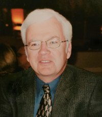 Man in suit and tie smiling indoors.
