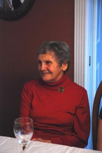 Elderly woman in red sweater sitting at table