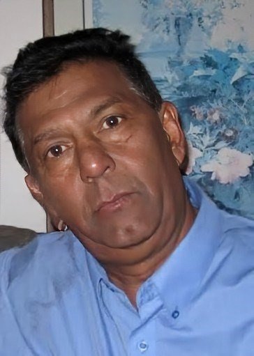 Person wearing blue shirt in front of painting.