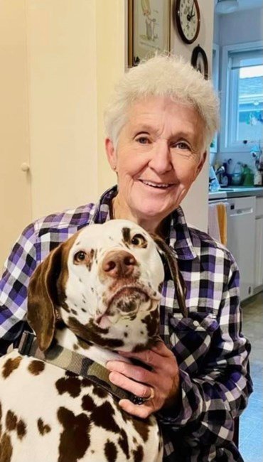 Smiling person with a Dalmatian dog indoors.