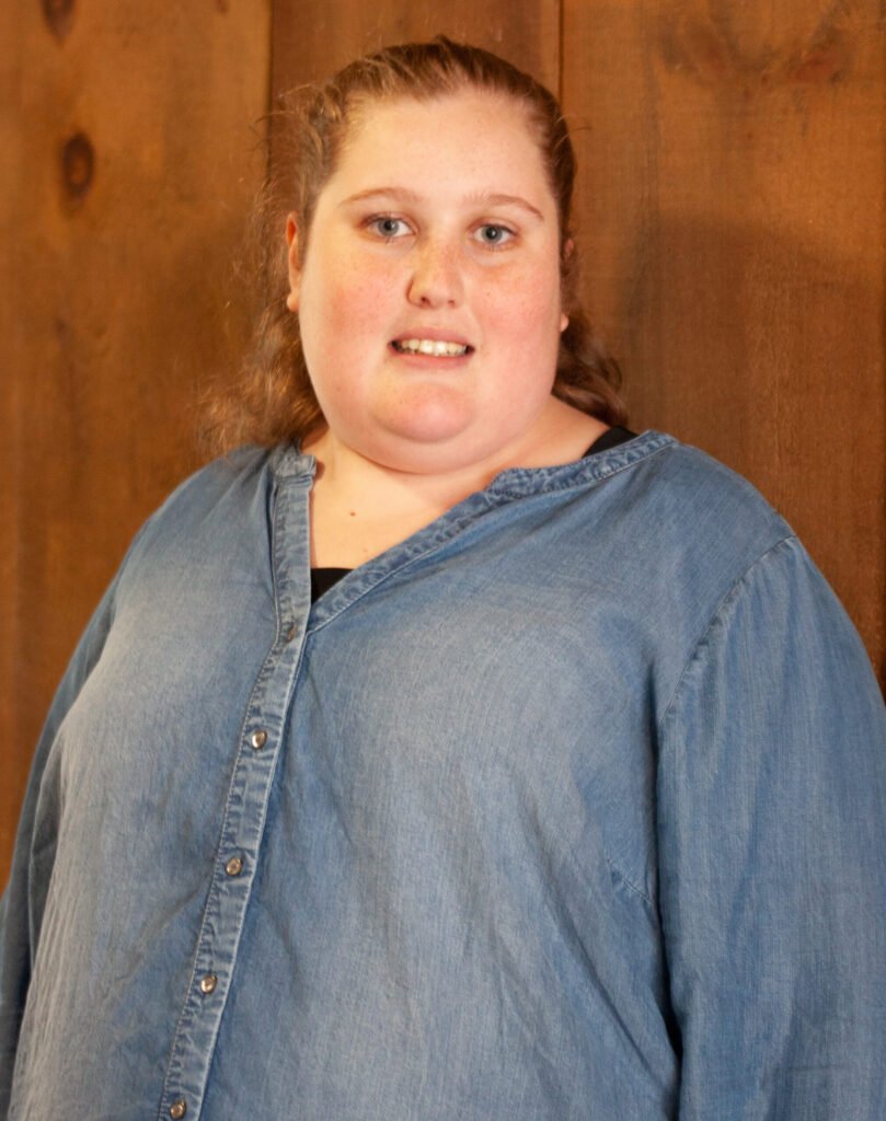 CARNEGIE, Rachel Grace Carnegie Person in denim shirt against wooden background
