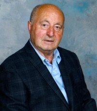 Elderly man in a suit with a blue background