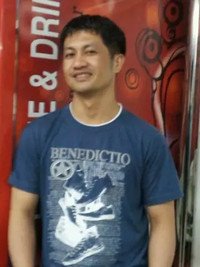 Smiling man in blue graphic t-shirt with designs.