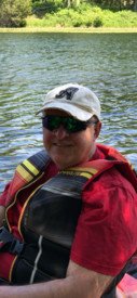 Person in a kayak on a sunny lake.