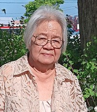 Elderly woman outdoors with greenery and trees