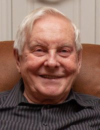 Smiling elderly man sitting on a chair indoors