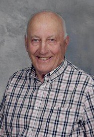 Smiling older man in plaid shirt portrait.